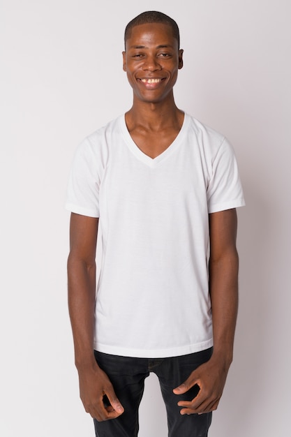 Studio shot of young handsome bald African man against white background