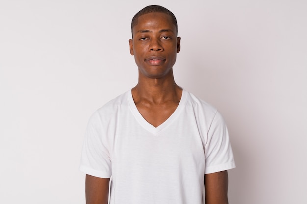 Studio shot di bel giovane uomo africano calvo su sfondo bianco