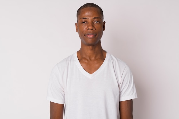 Studio shot of young handsome bald African man against white background