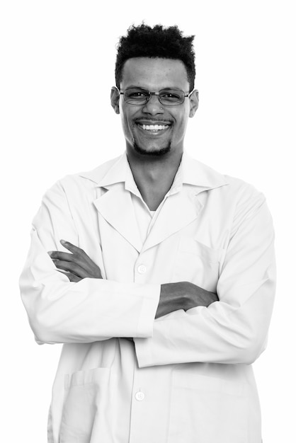 Photo studio shot of young handsome bearded african man doctor isolated against white background in black and white