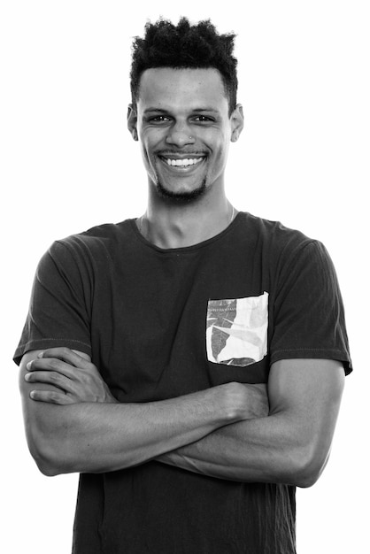 Studio shot of young handsome bearded African man with afro hair isolated against white background in black and white