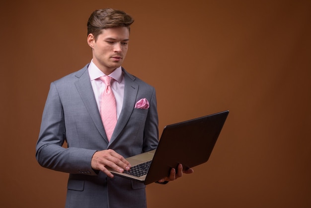 Studio shot of young handsome businessman in suit