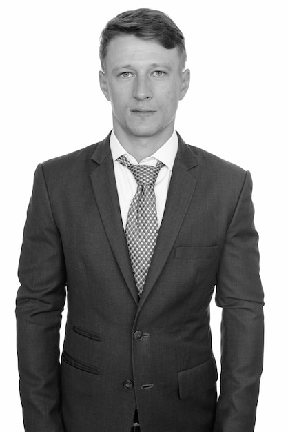 Studio shot of young handsome businessman wearing suit isolated, black and white