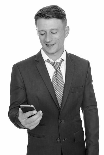 Studio shot of young handsome businessman wearing suit isolated, black and white