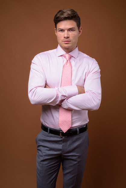 Studio shot of young handsome businessman with pink shirt