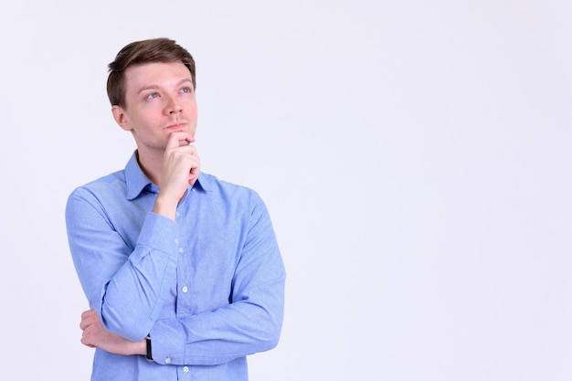 Studio shot of young handsome casual businessman against white