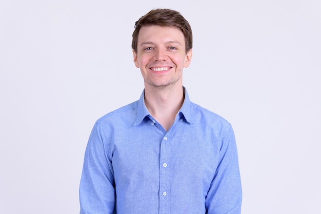 Studio shot of young handsome casual businessman against white