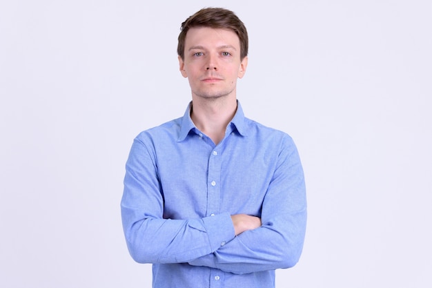 Studio shot of young handsome casual businessman against white