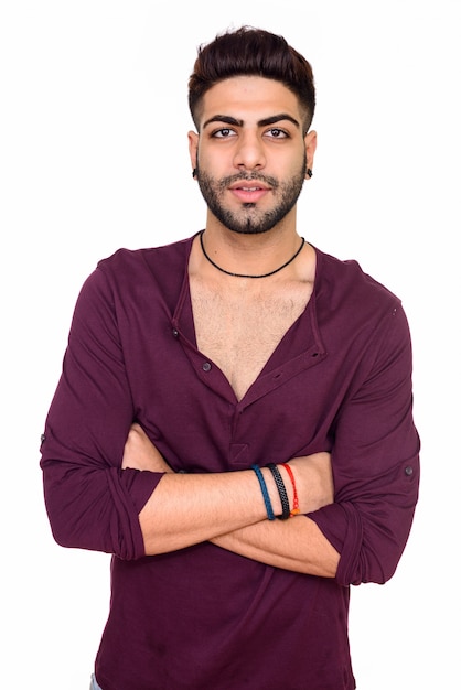 Studio shot of young handsome Indian man isolated against white background