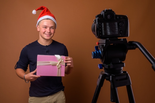 Studio shot of young handsome man against brown 