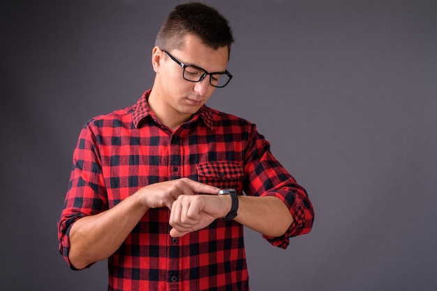 Studio shot of young handsome man against gray background