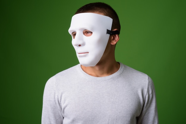 Studio shot of young handsome man against green background