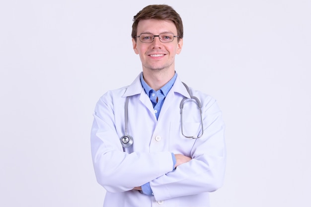 Studio shot of young handsome man doctor with eyeglasses against white