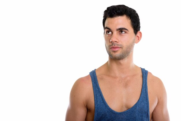 Studio shot of young handsome man thinking while lookin