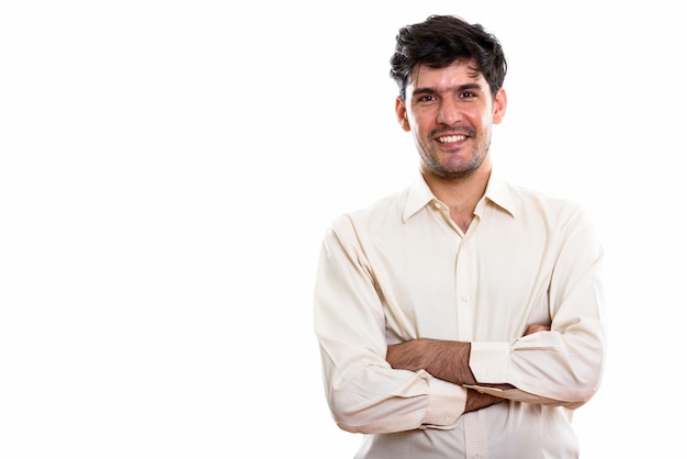 Studio shot of young happy Persian businessman smiling with arms