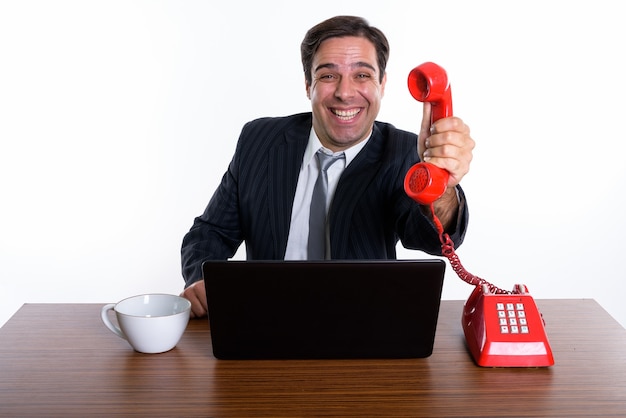 Studio shot of young happy Persian businessman smiling