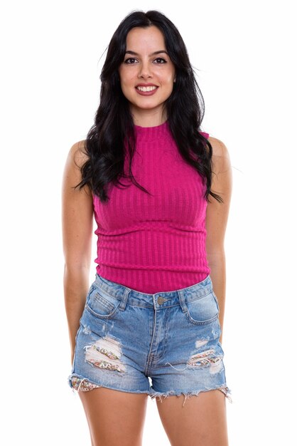 Studio shot of young happy Spanish woman smiling while standing