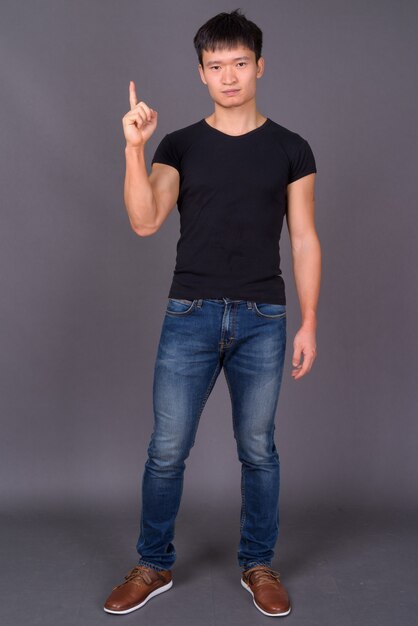 Studio shot of young man against gray