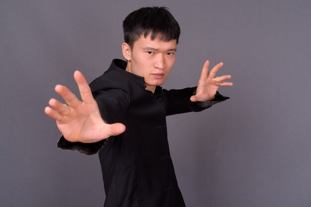 Studio shot of young man against gray