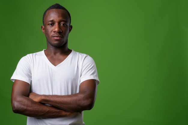 Studio shot of young man against green