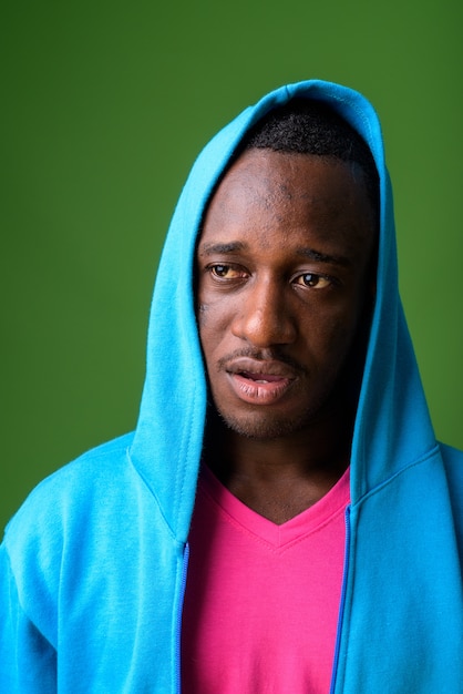 Studio shot of young man against green