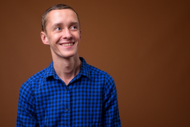 Studio shot of young man on brown