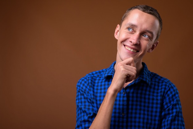 Studio shot of young man on brown