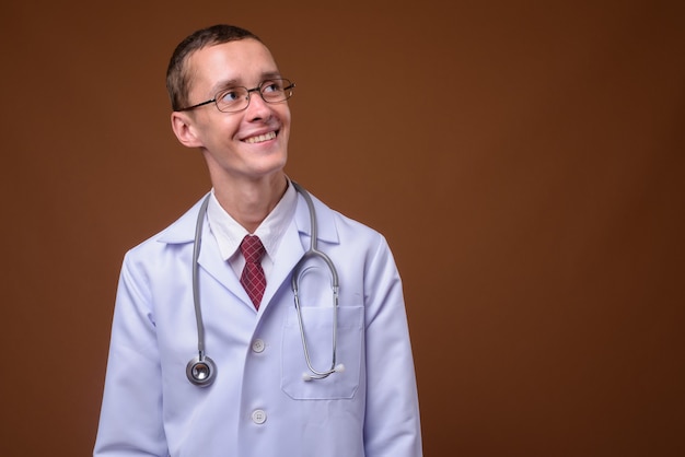 Studio shot of young man doctor on brown