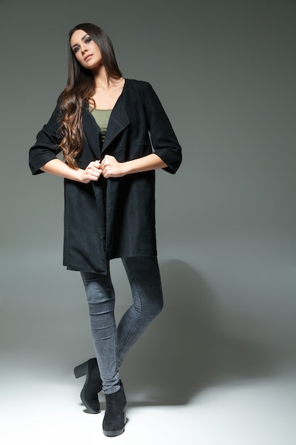 Studio shot of young model posing in fashionable clothing and looking at camera.