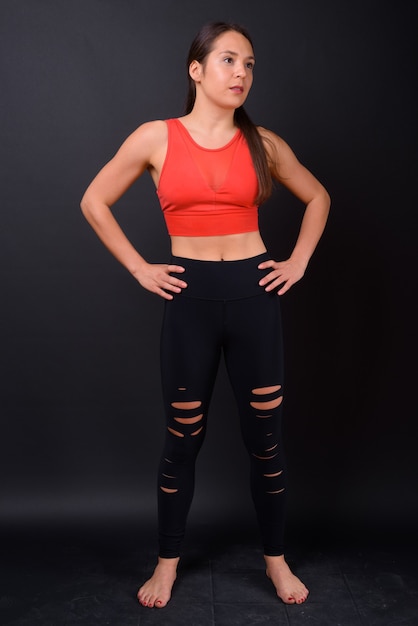Studio shot of young multi ethnic beautiful woman ready for gym against black background