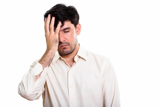 Photo studio shot of young persian businessman looking tired while cov