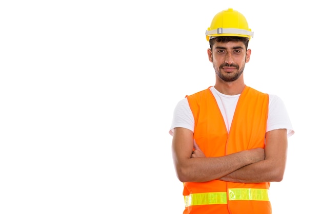 Studio shot of young Persian man construction worker with arms c