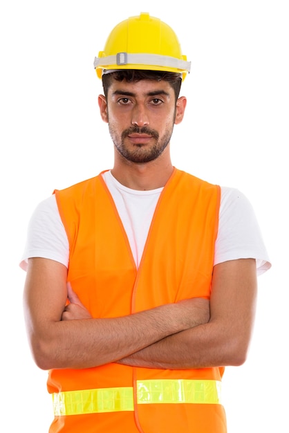 Studio shot of young Persian man construction worker with arms c