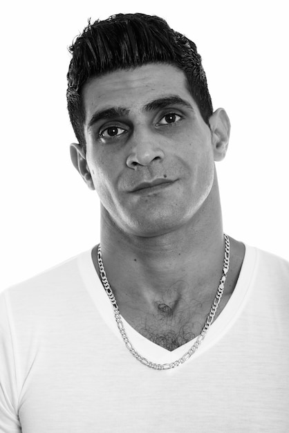 Studio shot of young Persian man isolated against white background in black and white