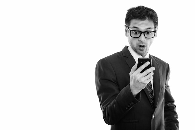 Studio shot of young skinny businessman wearing suit isolated, black and white