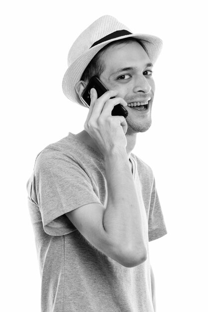 Studio shot of young skinny tourist man ready for vacation isolated, black and white