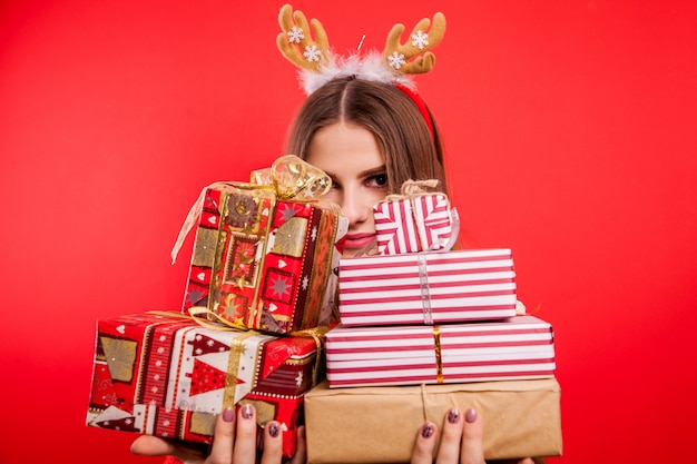 Foto colpo dello studio dei contenitori di regalo di una tenuta della giovane donna. concetto di celebrazione di natale o capodanno.