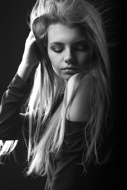 Studio zwart-wit portret van een mooie jonge vrouw poseren met blote schouders