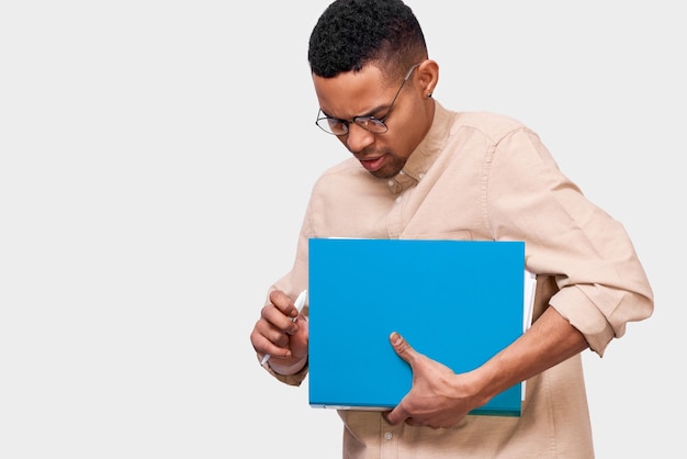 Studiobeeld van jonge Afro-Amerikaanse student met map met documenten Zelfverzekerde Afro-man in casual outfit met map met papieren en documenten met kopieerruimte voor reclame