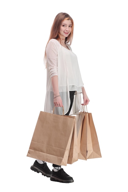 Studiofoto van een mooie vrouw die loopt met papieren boodschappentassen