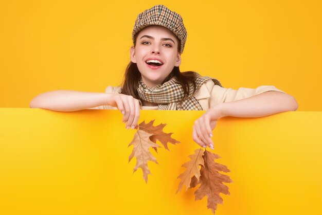 Studioportret van een jonge vrouw met herfstbladeren