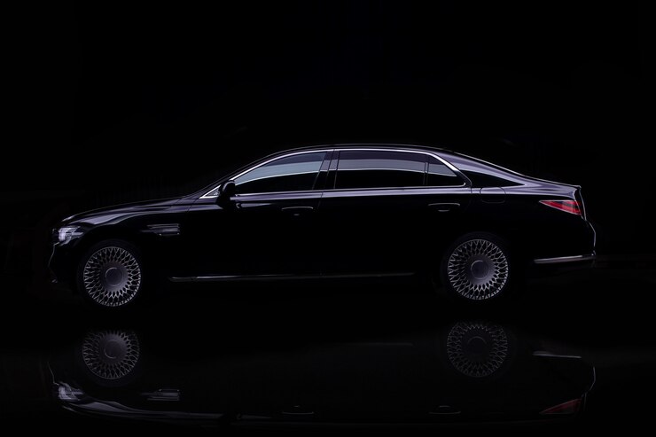 Studioschot van zwarte luxeauto die op zwarte wordt geïsoleerd