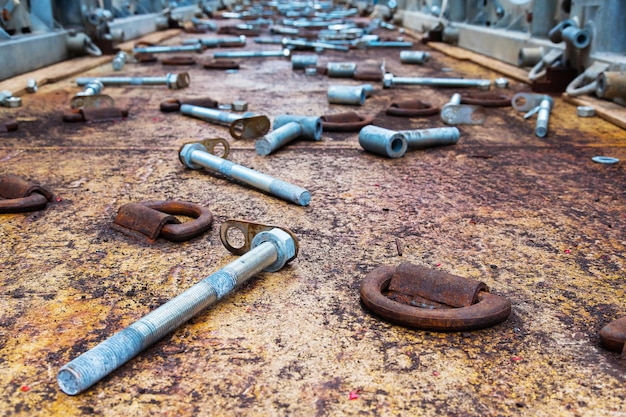 Studs bushings nuts washers lie on the deck after cargo unfastening Drings are welded onto the deck