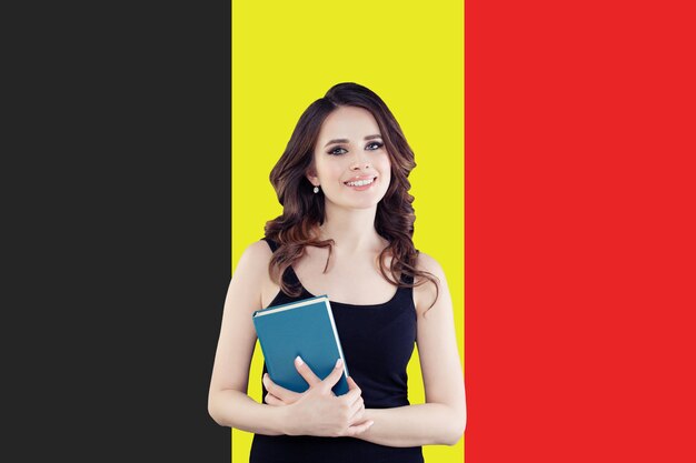 Photo study in belgium happy smart woman student on belgian flag background