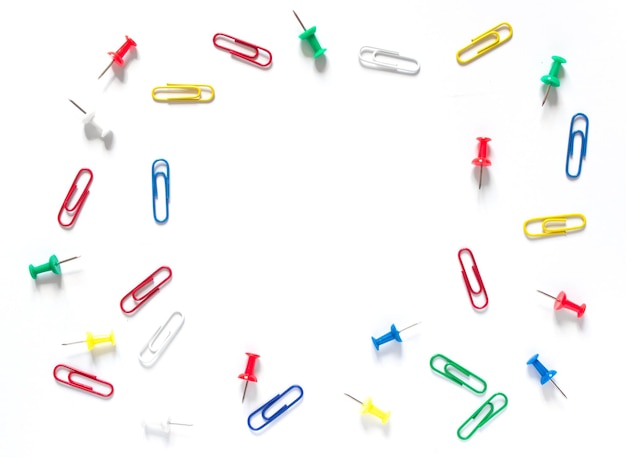 Photo study concept background. colorful office stationery: drawing pins and clips on white background with copy space