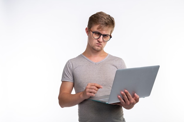 Study, education and people concept. a serious young handsome man look at netbook on white background.