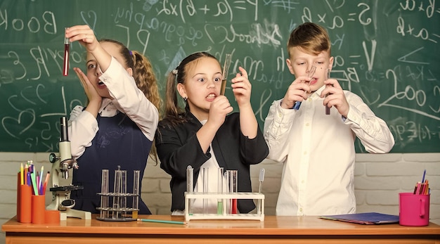 Photo study of liquid states group school pupils study chemical liquids girls and boy student conduct experiment with liquids check result teamwork concept test tubes with colorful liquid substances