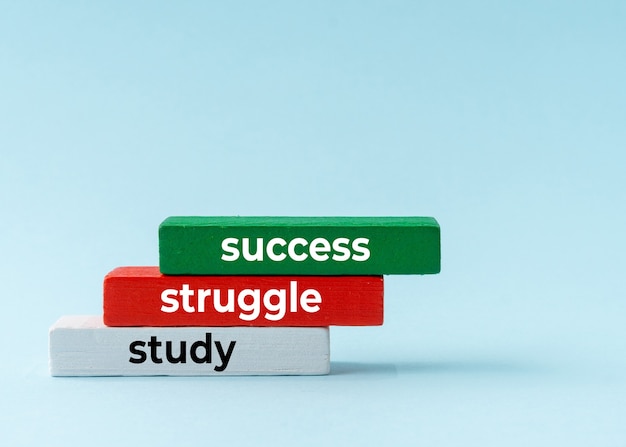 Study, struggle and success concept on colorful wooden block.