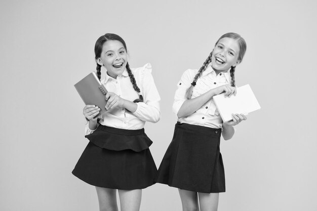 Photo study together knowledge day school day girl with copy books or workbooks kids cute students schoolgirls best friends excellent pupils school friendship schoolgirls wear school uniform