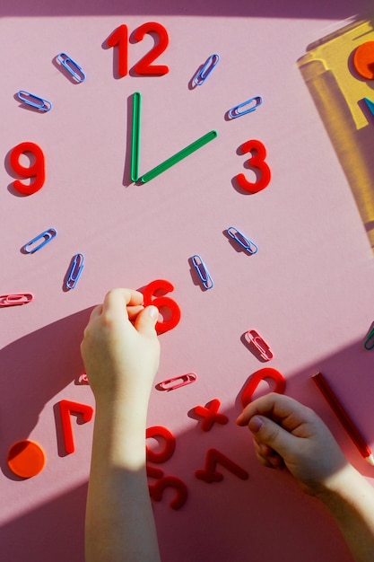 Foto studiare il tema delle ore con i bambini l'orologio è fatto di numeri graffette e bastoncini da